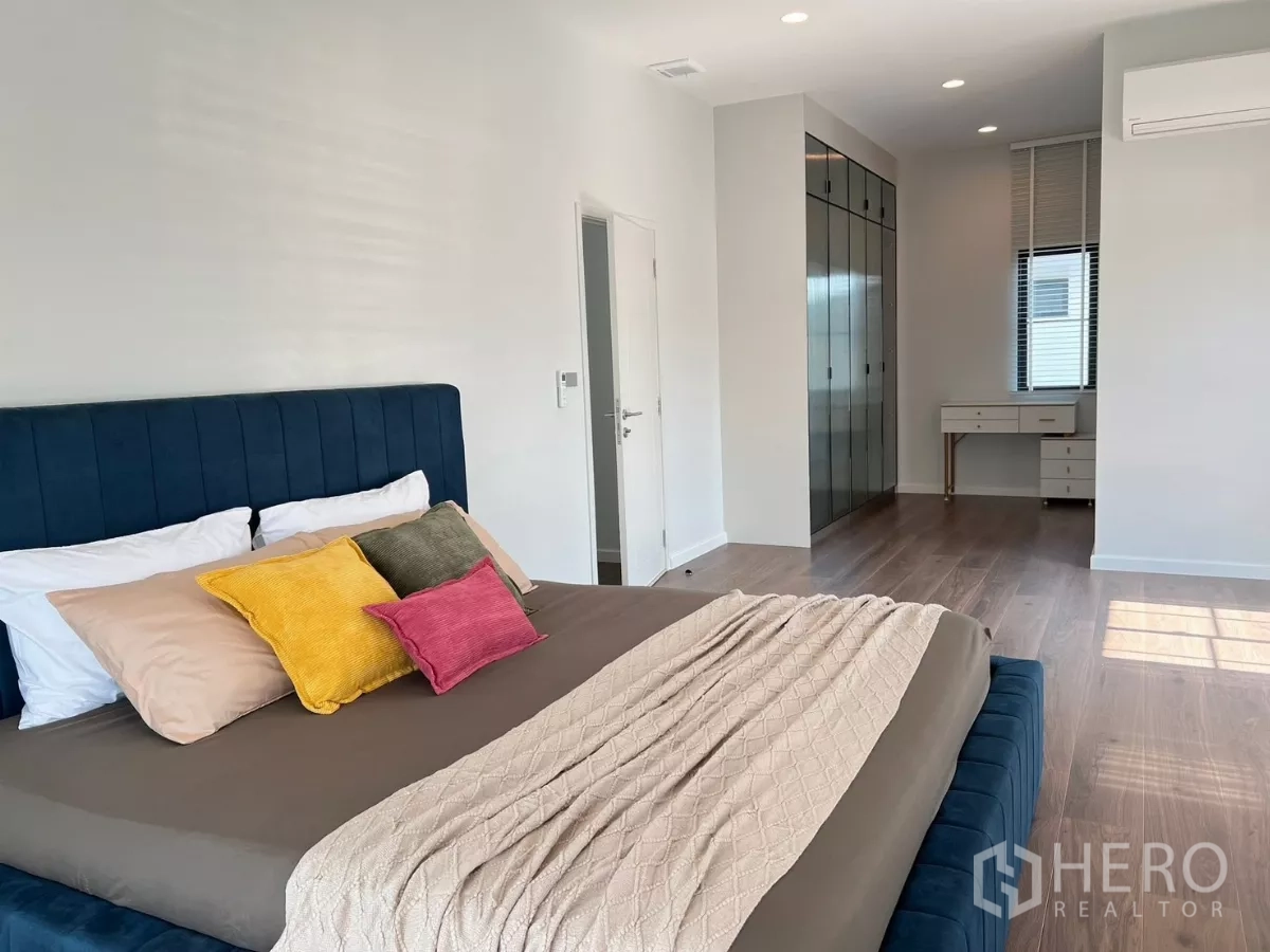 Detached House for rent in Khan Na Yao, Bangkok - Primary suite angle showing dressing area, glass wardrobes and wood floors.