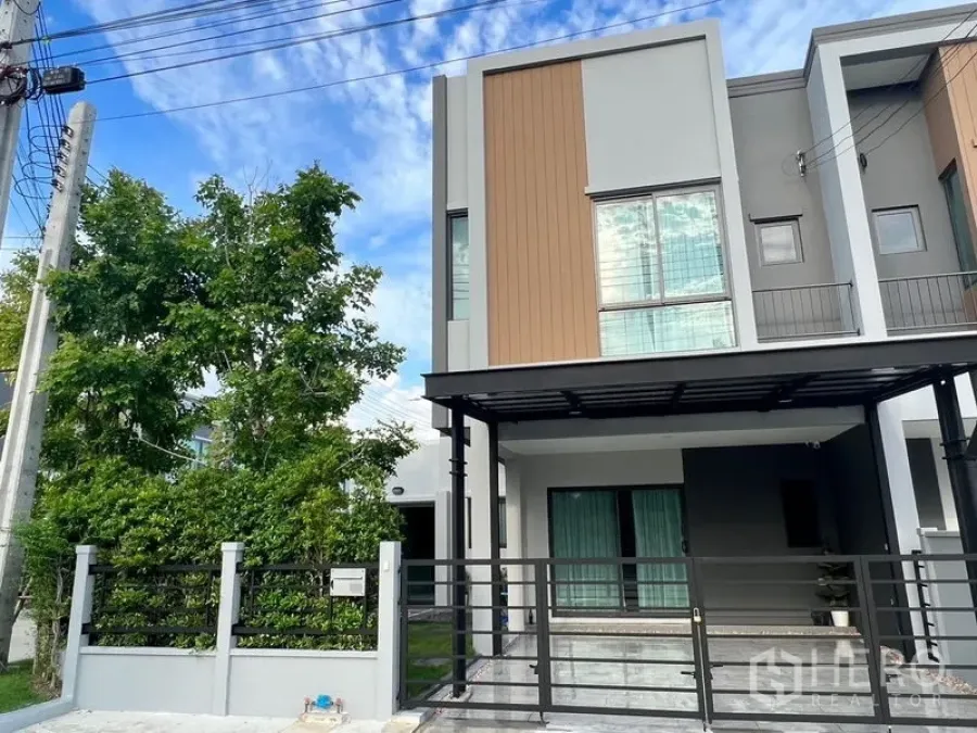 Townhouse for rent - Modern two-storey corner townhouse facade with gated carport and large windows.
