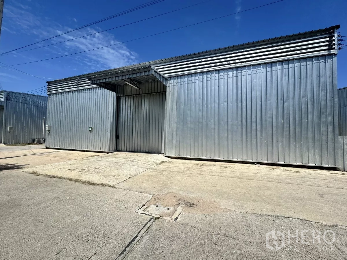 货栈 出租在Bang Lamung, Chon Buri - 邦拉蒙金属板仓库外观，超大推拉门与宽阔混凝土场地。