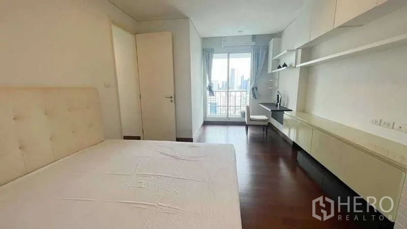 คอนโด ให้เช่าในWatthana, Bangkok - ห้องนอนใหญ่มีชั้นวางยาว โต๊ะทำงาน และทางออกสู่ระเบียงชมวิวเมือง