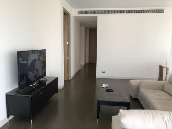 公寓 出租在Pathum Wan, Bangkok - 宽敞起居区，电视柜与大理石桌，走廊入口与木地板一览无遗。