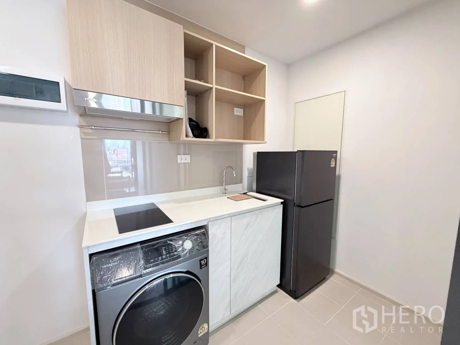 公寓 for rent in Din Daeng, Bangkok - 紧凑厨房设电磁炉、水槽、开放式吊柜、前开式洗衣机和冰箱。
