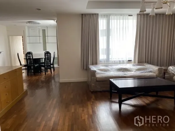 Condominium for rent or sale in Sathon, Bangkok - Bright lounge with floor-to-ceiling curtains and an adjoining dining zone in a 2-bedroom condo.