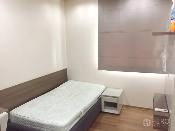 Condominium for rent in Bang Rak, Bangkok - Cozy second bedroom with single bed, wood floors and blackout roman shade.