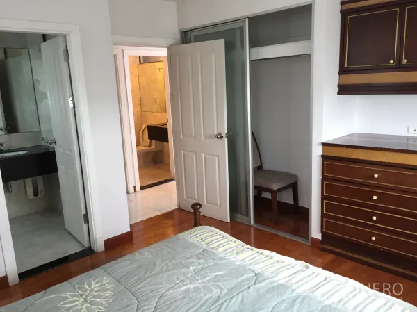 Condominium for rent in Watthana, Bangkok - Bedroom with wood floors, built-in wardrobe and direct access to two bathrooms.