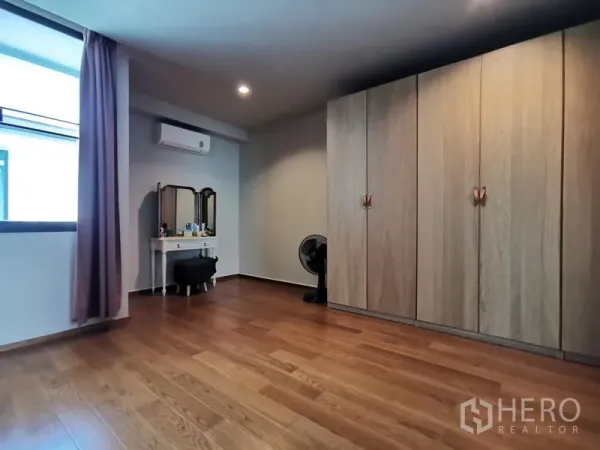 Townhouse for sale - Bedroom with full-height built-in wardrobes, dressing table and wood flooring.