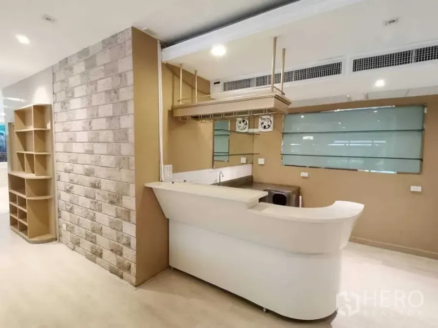 Retail Space for rent in Pathum Wan, Bangkok - Reception counter with sink, shelving and stone accent wall in a modern retail space.