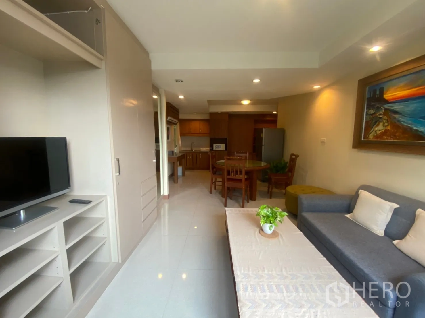 Condominium for rent in Phaya Thai, Bangkok - Second lounge with sofa, TV unit, and dining area beside a full kitchen.