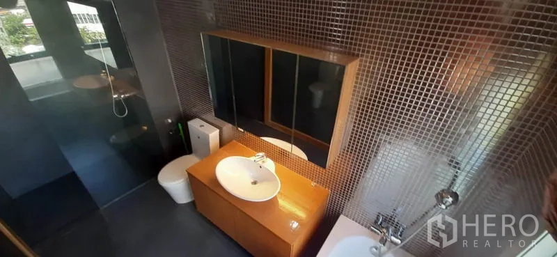 Condominium for rent in Phaya Thai, Bangkok - Bathroom with walk-in shower, toilet, mirror cabinets and mosaic-tiled walls.