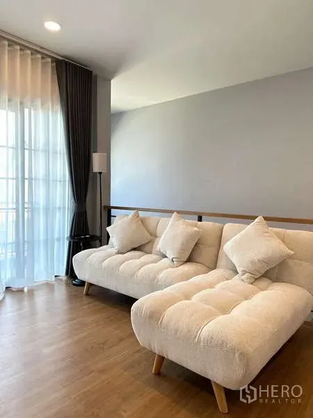 Detached House for rent in Bang Phli, Samut Prakan - Upstairs family lounge with two tufted cream sofas beside full-height windows.