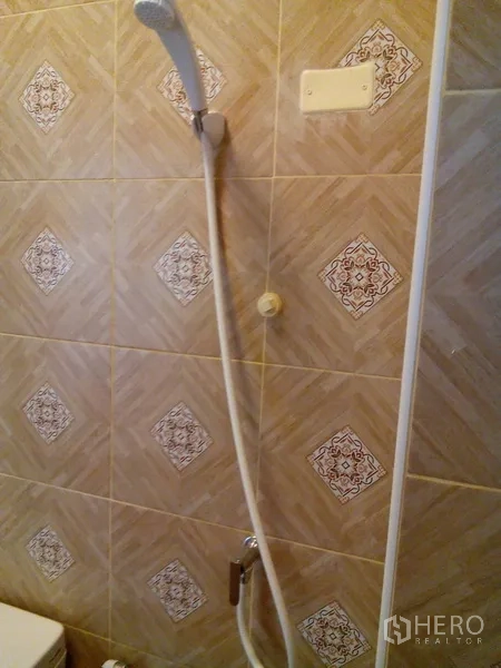 Shophouse for rent in Phra Khanong, Bangkok - Wall-mounted shower head with beige patterned ceramic tiles.