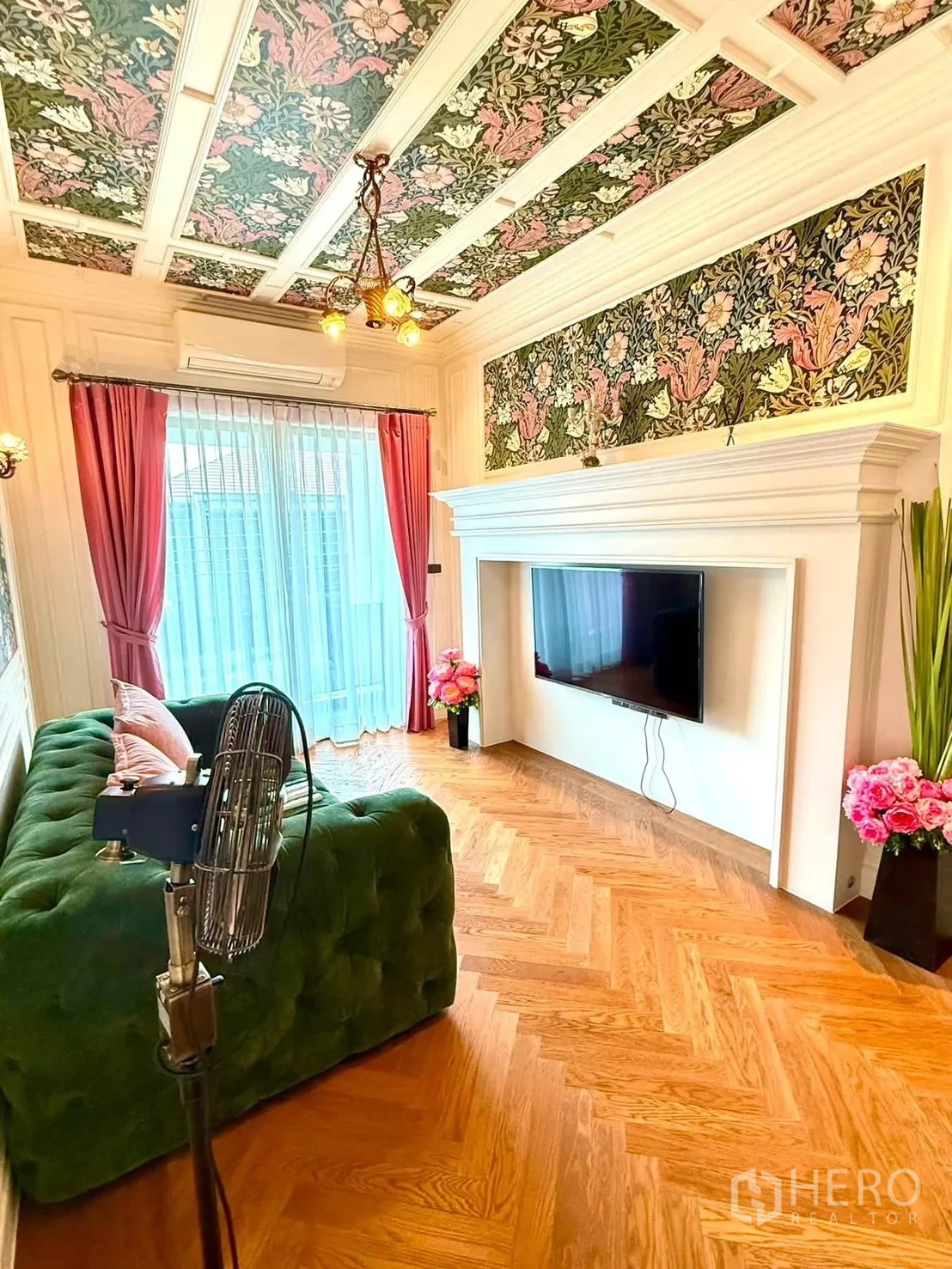 Detached House for rent in Bang Kapi, Bangkok - Cozy TV lounge with green tufted sofa, floral panels, and sheer curtains.
