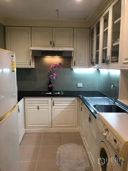 Condominium for rent or sale in Sathon, Bangkok - U-shaped kitchen with ample cabinetry, sink, cooktop, refrigerator and washing machine.