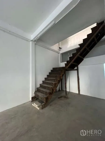 Shophouse for rent in Watthana, Bangkok - Wooden staircase leading to the upper level inside the shophouse.