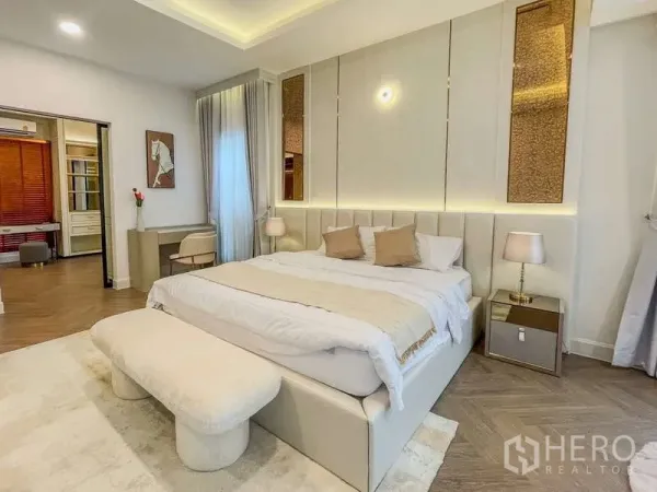 Detached House for rent in Saphan Sung, Bangkok - Elegant master bedroom with upholstered headboard, soft lighting and access to a walk-in area.