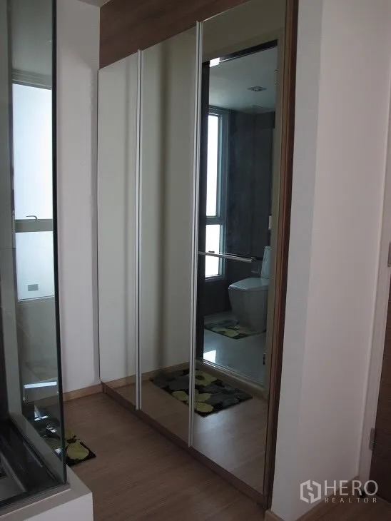 Condominium for rent or sale in Khlong Toei, Bangkok - Hallway with mirrored built-in wardrobe beside the bathroom entrance.