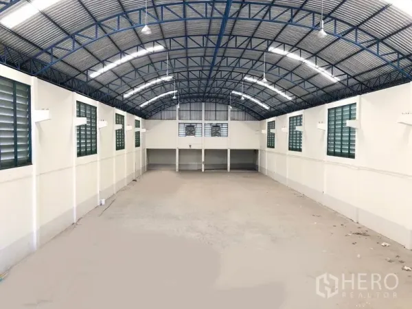 工厂 出租在Samut Prakan - 通透的长型生产车间，侧墙百叶窗通风，LED照明与平整混凝土地面。