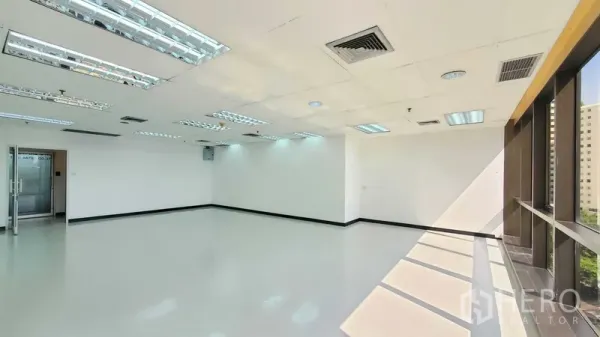 办公空间 出租在Watthana, Bangkok - 转角办公室内景，窗墙采光充足，亮面地坪、玻璃入户门与吊顶出风口。