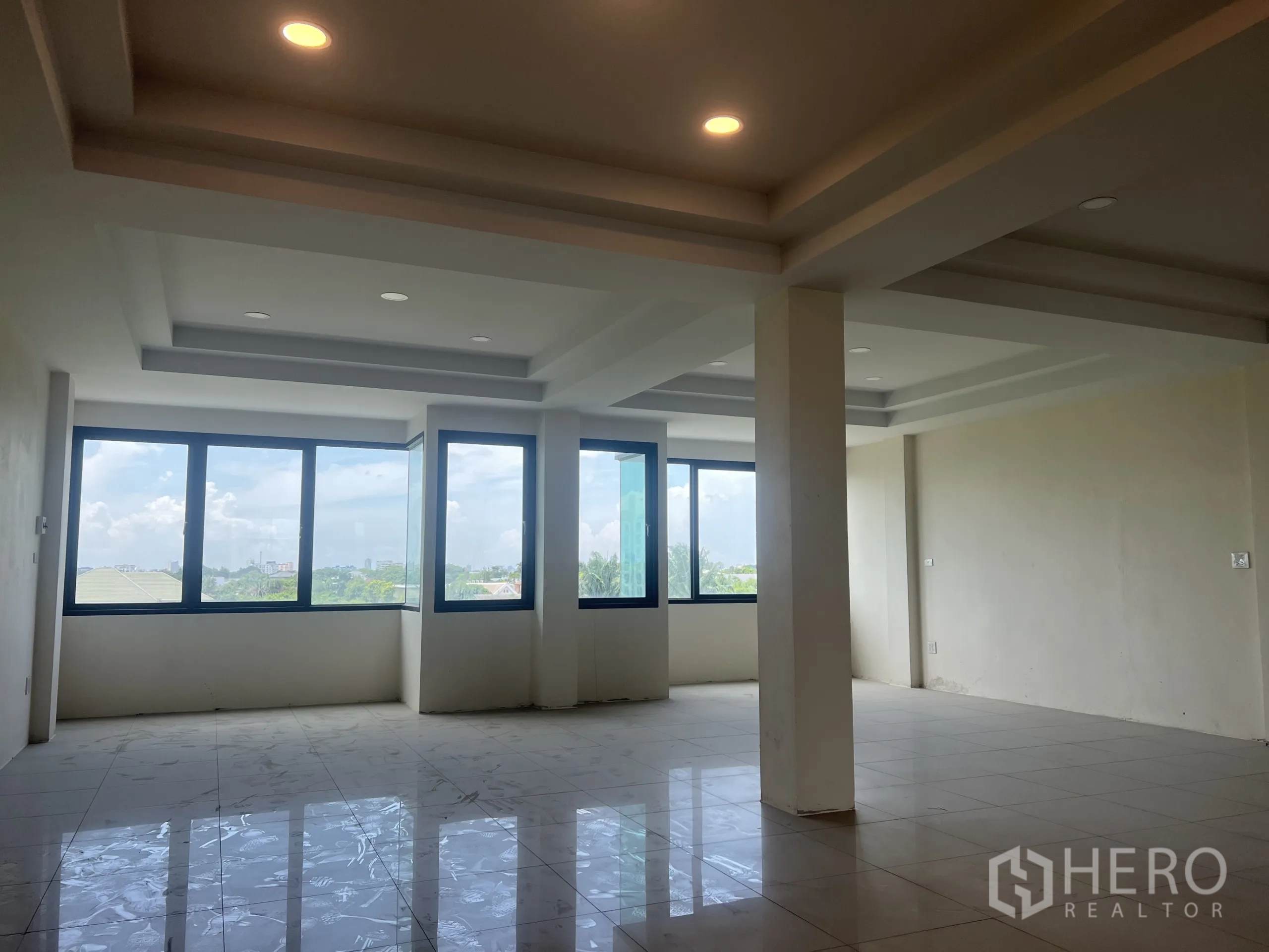 带办公室的家 出租在Suan Luang, Bangkok - 采光充足的开间楼层，转角大窗与嵌入式照明，亮面地砖与城市景观