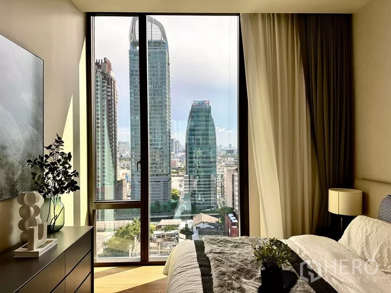 คอนโด ให้เช่าในPathum Wan, Bangkok - ห้องนอนหลักมุมมองเมืองจากหน้าต่างสูงจรดเพดาน เห็นตึกสูงใจกลางกรุงเทพฯ