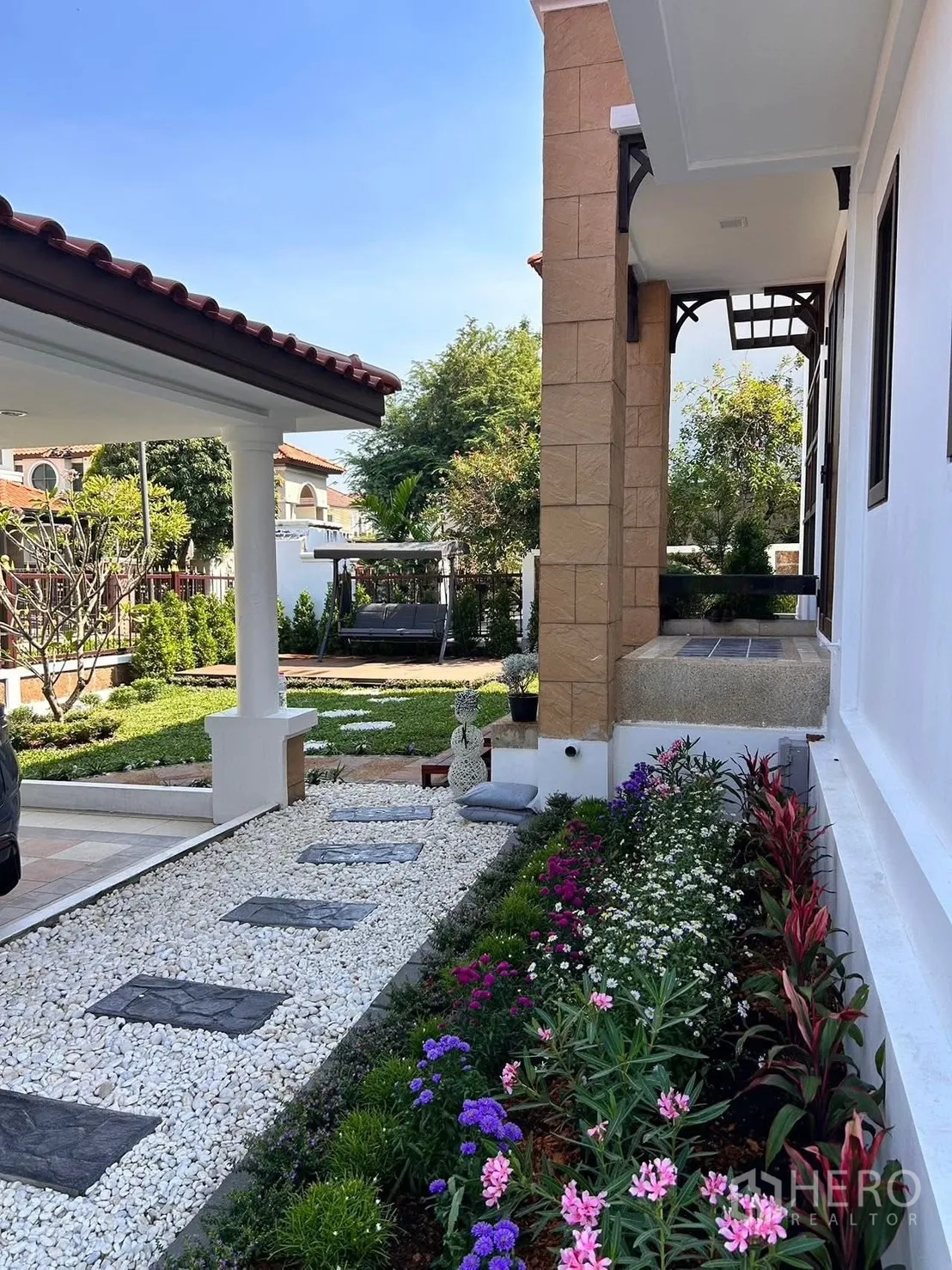 Detached House for rent in Lat Krabang, Bangkok - Side garden with pebble pathway, stepping stones and colorful flower border.