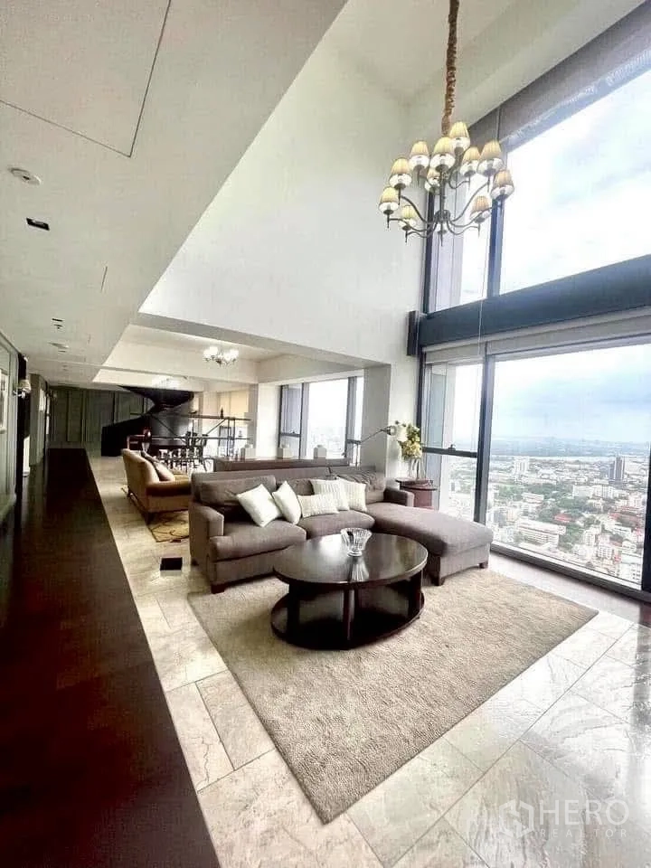 Condominium for rent in Sathon, Bangkok - High-floor open-plan living with marble flooring and wall-to-wall windows framing Bangkok skyline.