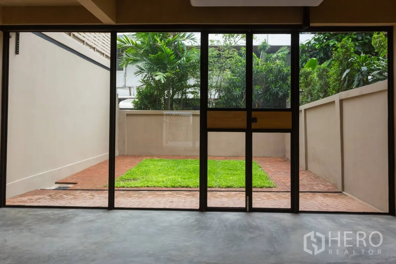 带办公室的家 出租在Watthana, Bangkok - 落地门外的私家庭院，草坪与砖铺露台。