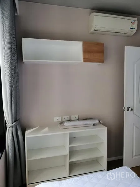 Condominium for rent in Watthana, Bangkok - Bedroom storage with wall-mounted shelves and air conditioner