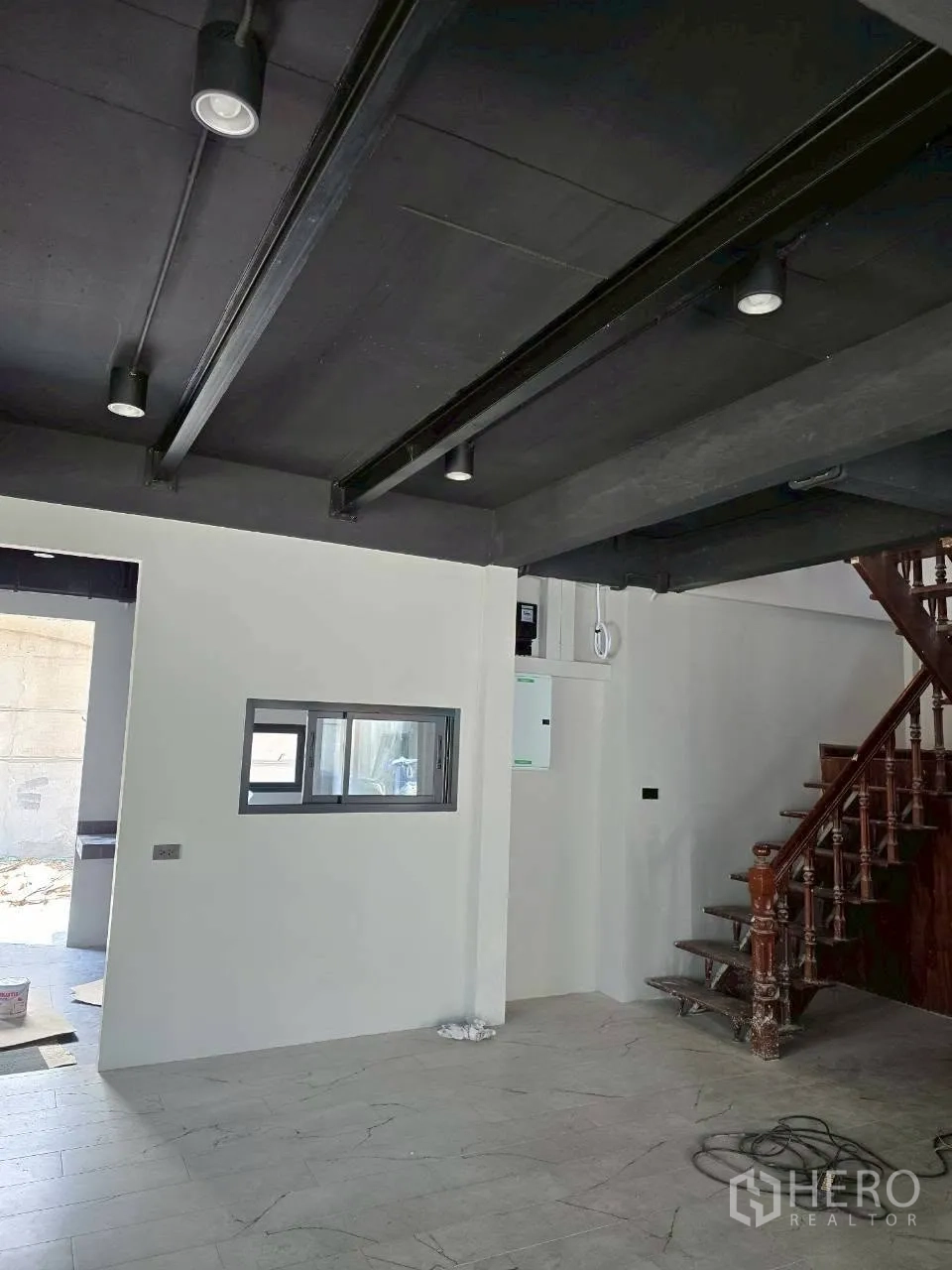独栋房屋 for rent in Phra Khanong, Bangkok - 起居空间带外露梁、服务窗口与木楼梯。