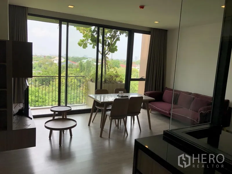คอนโด ให้เช่าในWatthana, Bangkok - พื้นที่นั่งเล่นรับประทานอาหาร พร้อมหน้าต่างเต็มผนัง ระเบียงและวิวต้นไม้เขียว