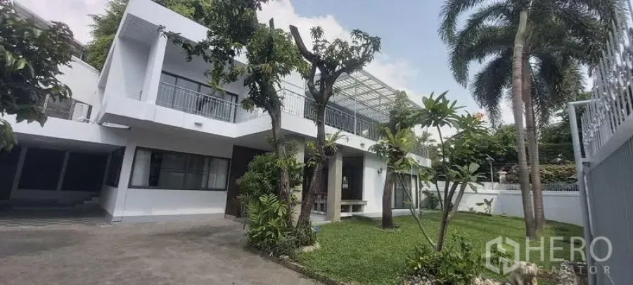 独立式住宅 出租在Pathum Wan, Bangkok - 两层白色独栋别墅，带草坪、绿树和封闭车道