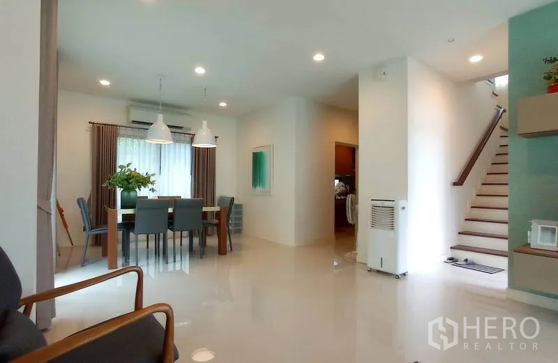 独立式住宅 出租在Bang Kapi, Bangkok - 开放式餐厅，吊灯照明，邻近楼梯与大窗。