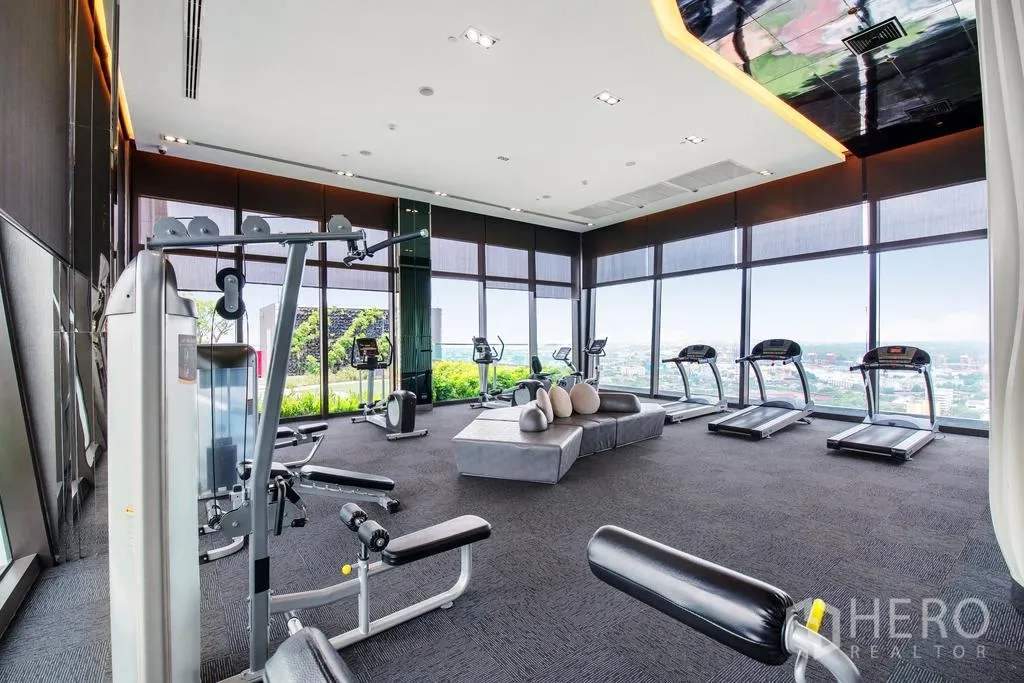 Condominium for rent or sale in Khlong Toei, Bangkok - Fully equipped fitness center with cardio machines and large windows overlooking the city.