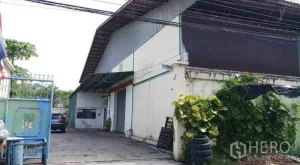 仓库 for rent in Bang Phli, Samut Prakan - 仓库外部入口，带卷闸门、雨棚装卸区和车道。