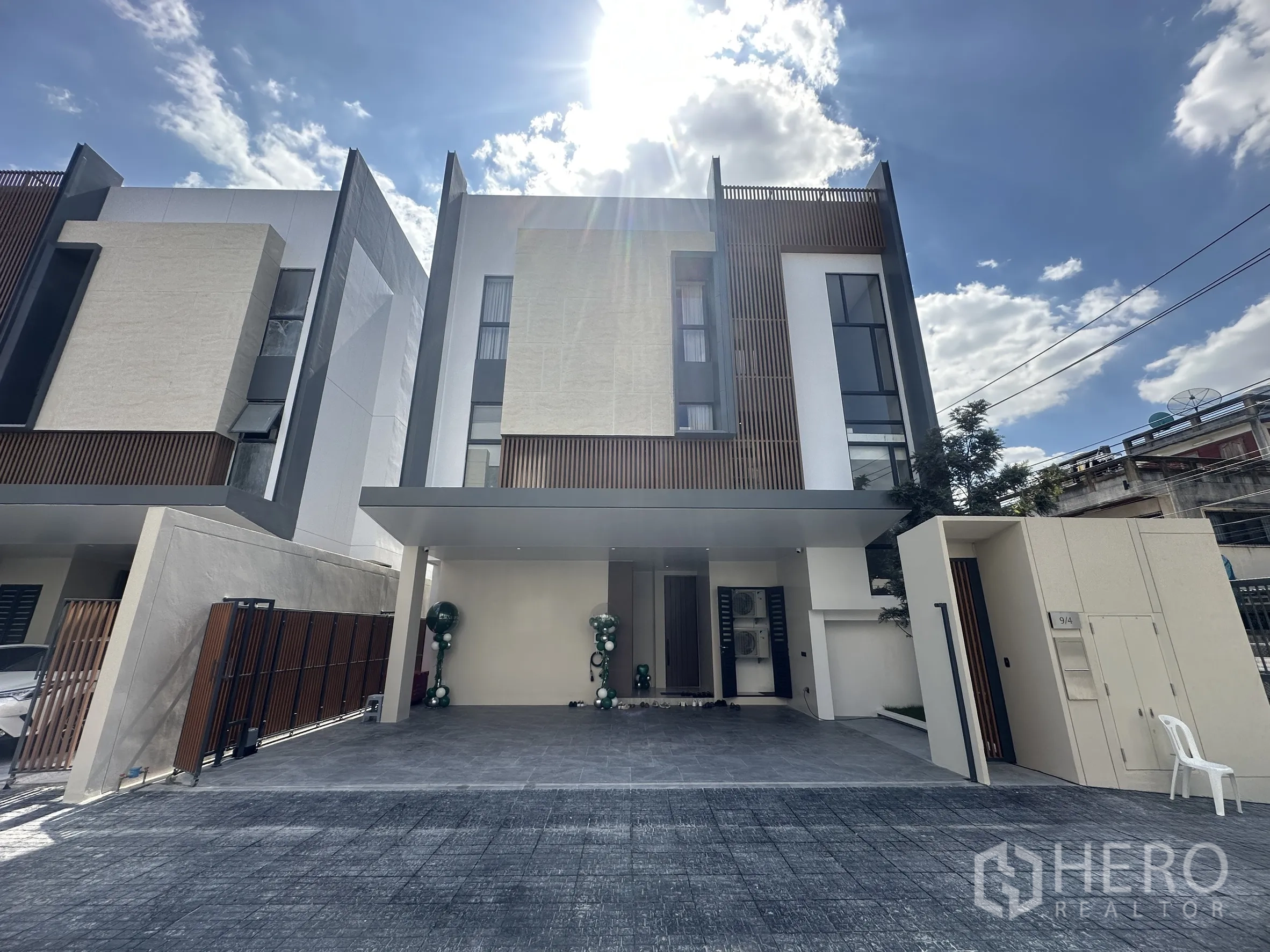 Detached House for sale in Lat Phrao, Bangkok - Modern three-storey detached house façade with covered parking in Lat Phrao.
