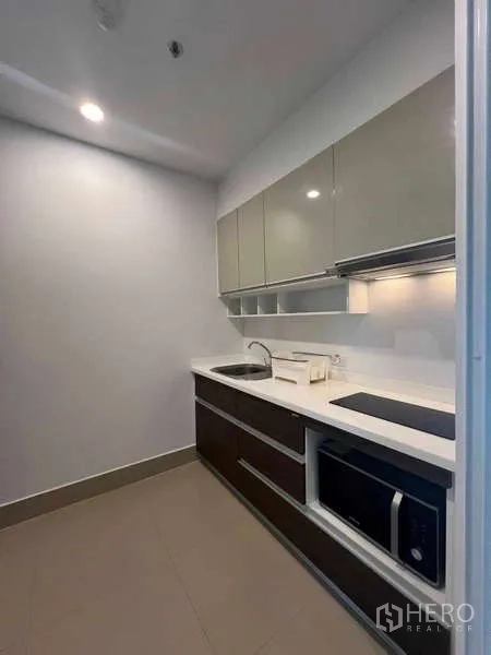 公寓 出租在Ratchathewi, Bangkok - 狭长型现代厨房，水槽、灶台与橱柜下灯带。