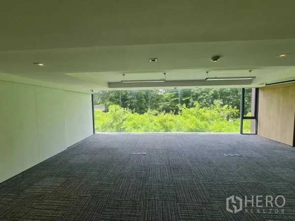 สำนักงาน ให้เช่าในWatthana, Bangkok - พื้นสำนักงานกว้าง กระจกพาโนรามิคมองเห็นต้นไม้ พื้นพรมเข้ม ช่องปลั๊กไฟใต้พื้น และไฟ LED ฝ้าเพดาน.