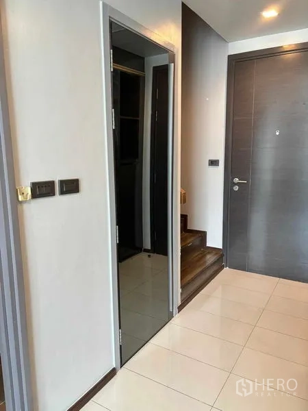 Condominium for rent or sale in Watthana, Bangkok - Entry hall with full-height mirror, tiled floor and short steps to a split-level area.