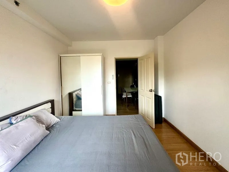公寓 出租在Huai Khwang, Bangkok - 卧室内有衣柜，门口通向客厅区域。