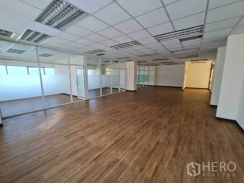 办公空间 出租在Watthana, Bangkok - 长形开放区，木地板通向玻璃围合的办公室