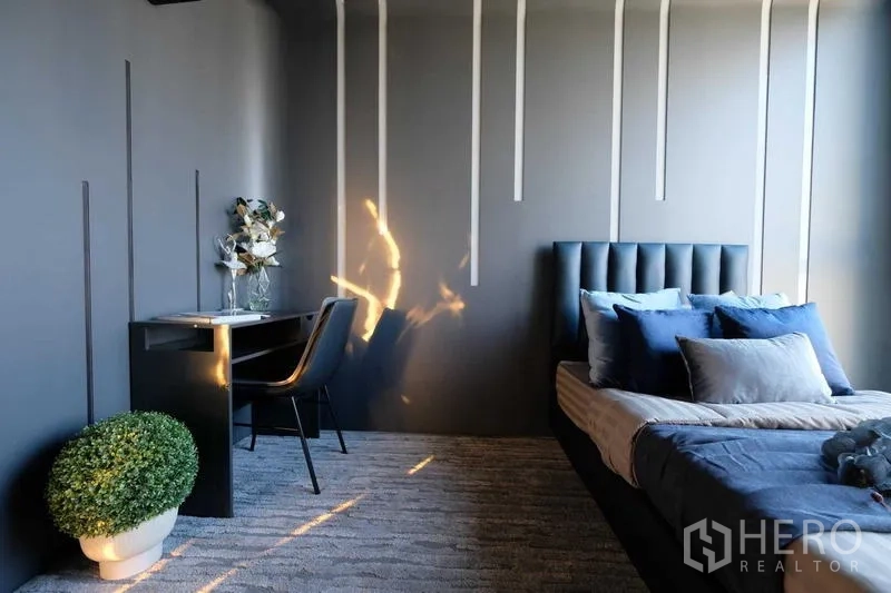 Condominium for sale - Bedroom corner with desk, potted plant and natural light.