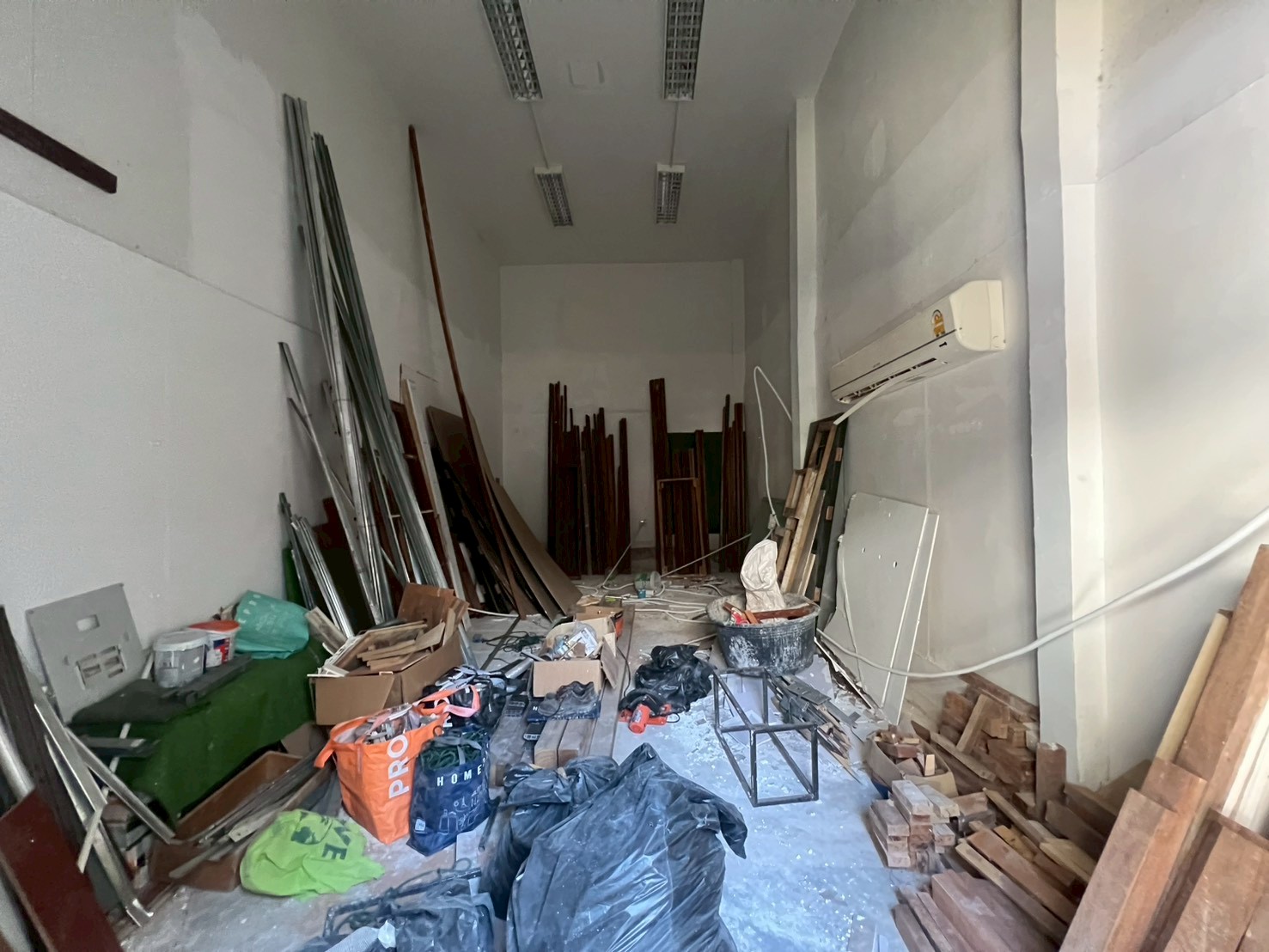 Retail Space for rent in Watthana, Bangkok - Back-of-house storage or workshop under renovation with high ceiling and white walls.