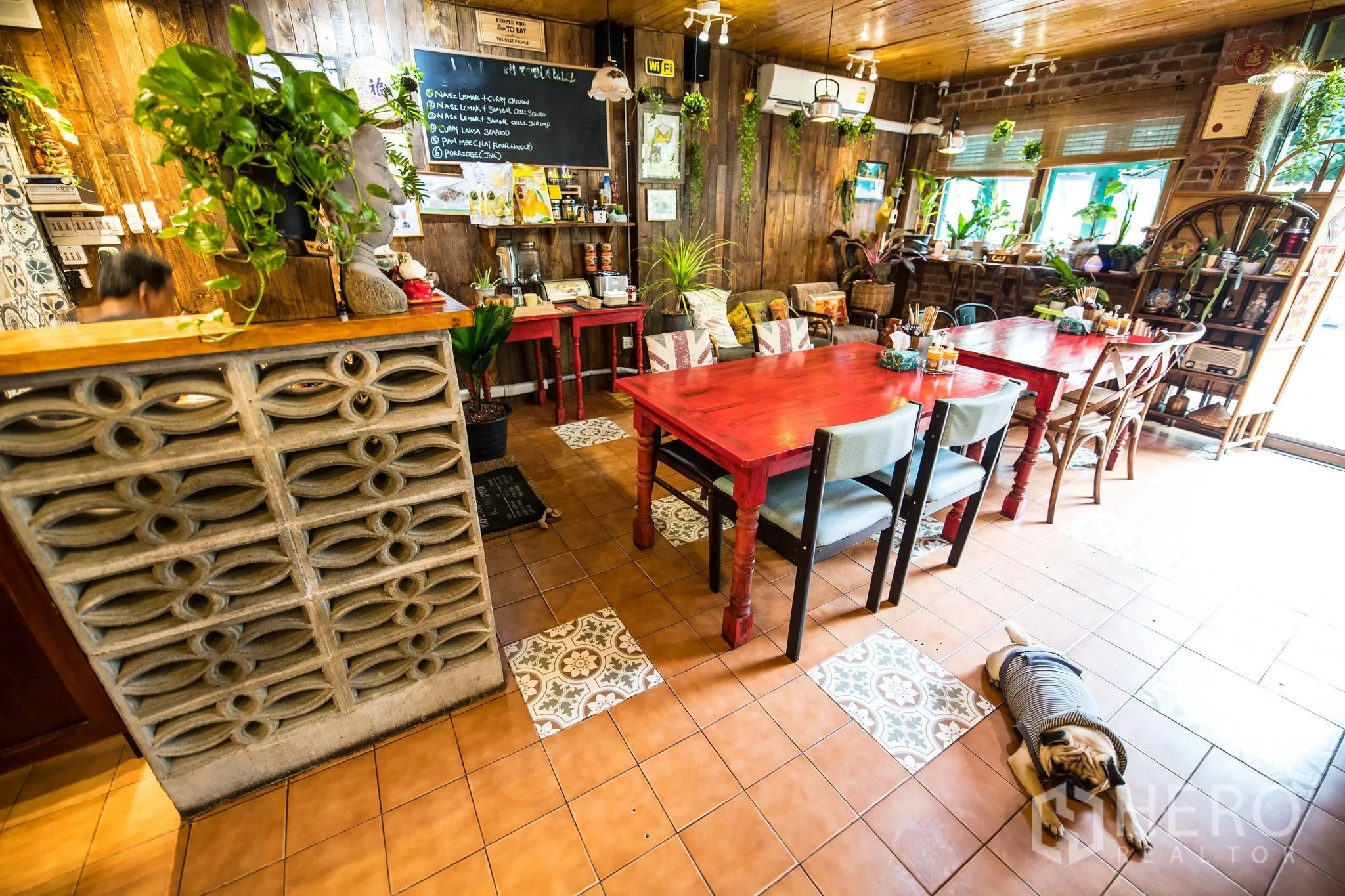 Retail Space for rent in Watthana, Bangkok - Warm cafe-style retail interior with red wooden tables, patterned floor tiles, and a chalkboard menu.