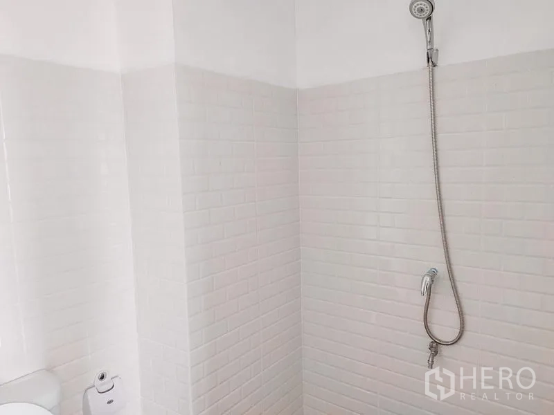 Townhouse for rent in Chatuchak, Bangkok - White tiled shower area with handheld shower and hose.