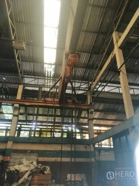 工厂 出租在Lam Luk Ka, Pathum Thani - 厂房内的行车梁与链式葫芦，屋顶采光板可见。