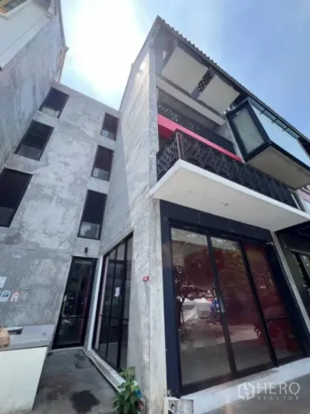 零售空间 出租在Khlong Toei, Bangkok - 四层转角建筑外观，带阳台和一层玻璃店面。