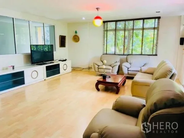 Detached House for rent in Watthana, Bangkok - Bright living room with light wood flooring, large windows, TV console and sofa set in a Watthana detached house.