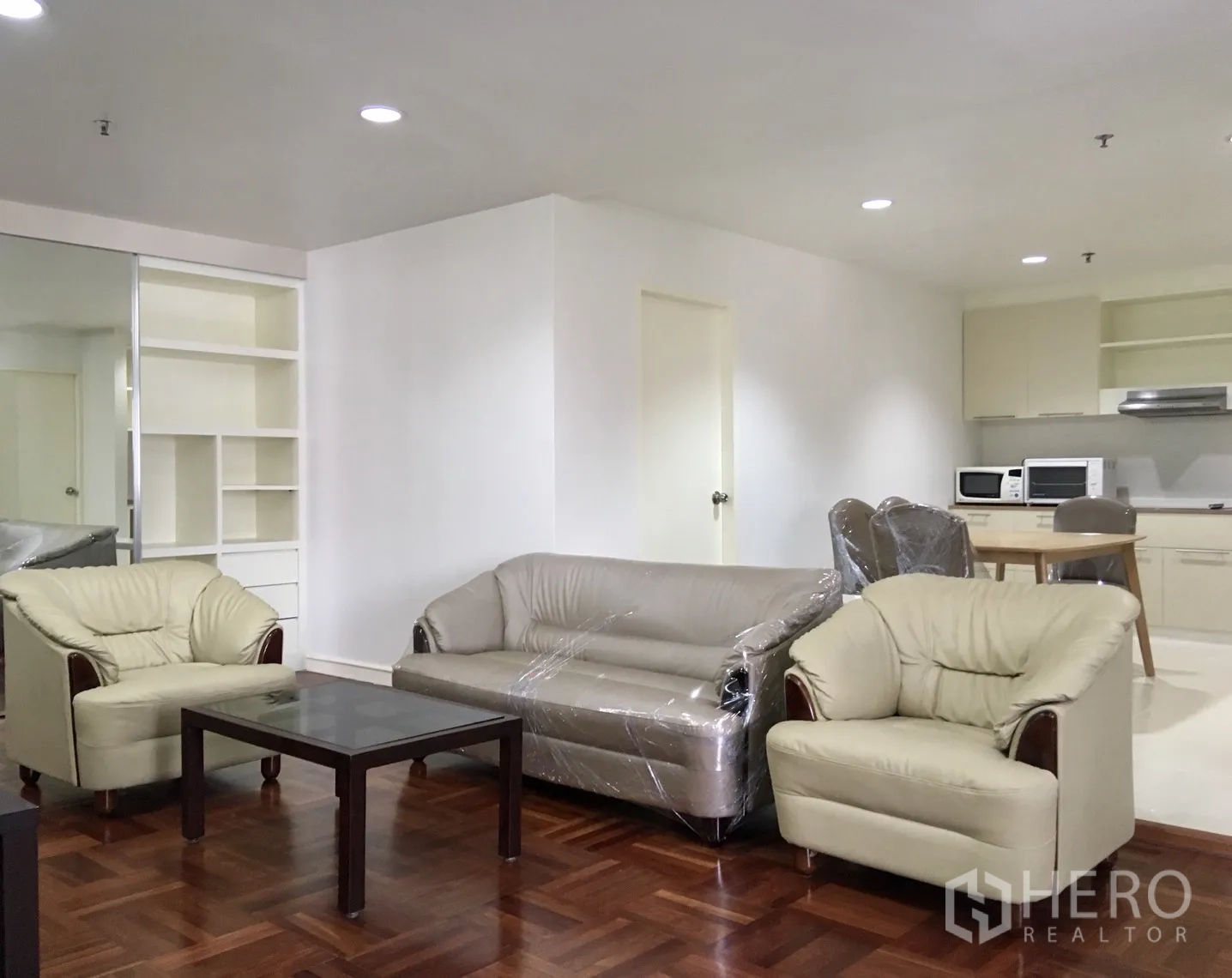 Condominium for rent or sale in Watthana, Bangkok - Open‑plan living and dining with sofa set, dining table and fitted kitchen.