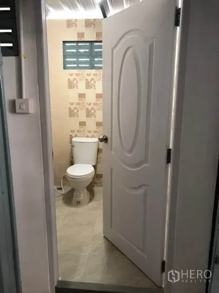 Warehouse for rent in Wang Thonglang, Bangkok - Clean restroom with toilet and tiled walls inside the warehouse compound.