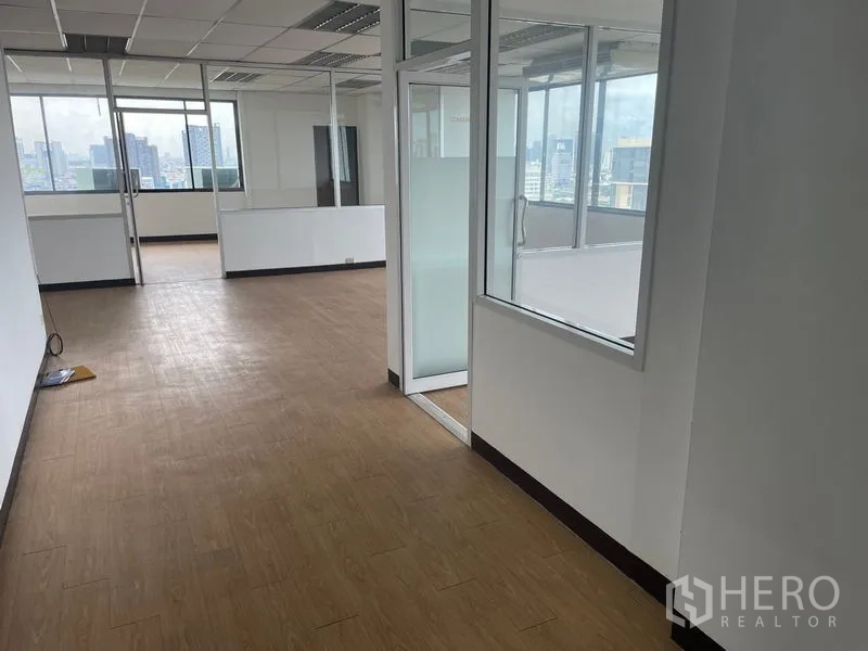 Office Space for rent in Din Daeng, Bangkok - Office corridor leading to glass-walled rooms with abundant natural light and city views.